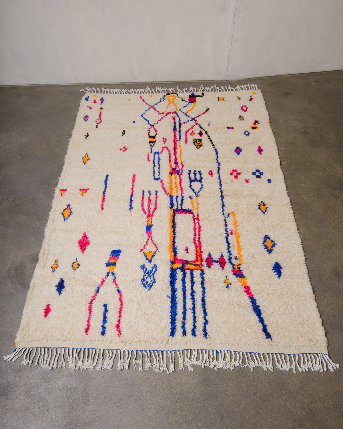 Berberlin Azilal rug made of fluffy wool and cotton, laying flat on a concrete floor.